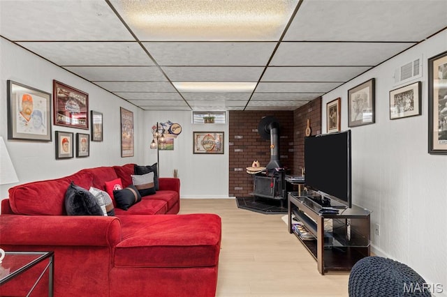 111 Freedom Dr, Belleville, IL 62226 - living area with light wood-style flooring, a paneled ceiling, and a wood stove