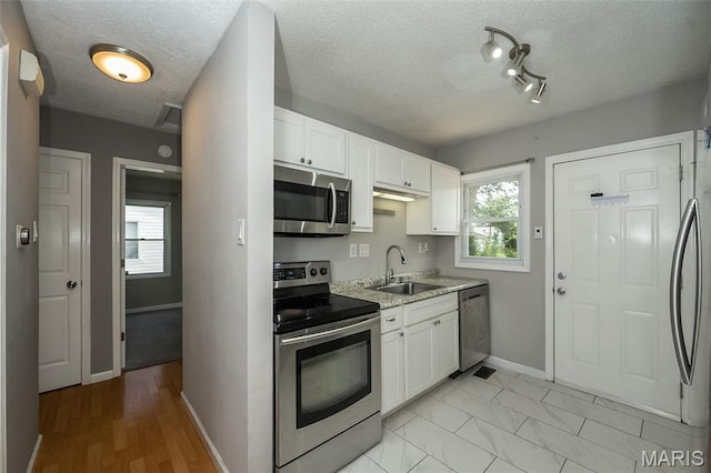 4322 Heidelberg Ave, Saint Louis, MO 63123 - kitchen featuring stainless steel appliances, white cabinets, and a textured ceiling