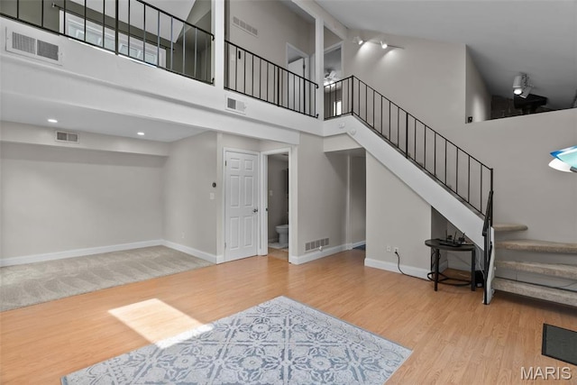 404 Applestone Dr, Ballwin, MO 63021 - unfurnished living room featuring stairs, a high ceiling, and wood finished floors