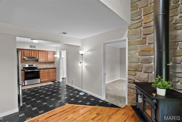 404 Applestone Dr, Ballwin, MO 63021 - kitchen with electric range, dark countertops, under cabinet range hood, brown cabinets, and tasteful backsplash