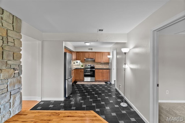 404 Applestone Dr, Ballwin, MO 63021 - kitchen with stainless steel appliances, under cabinet range hood, tasteful backsplash, and brown cabinets