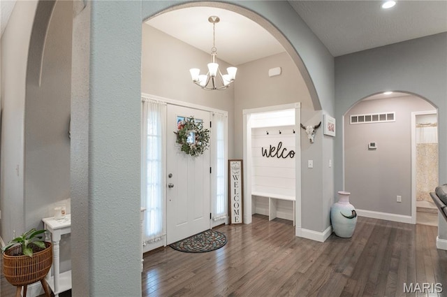 12200 Country Oaks Dr, Rolla, MO 65401 - foyer featuring arched walkways, a chandelier, and dark wood-type flooring
