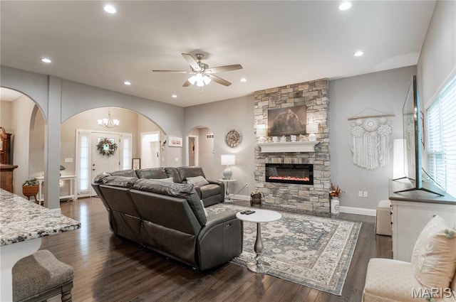 12200 Country Oaks Dr, Rolla, MO 65401 - living room featuring arched walkways, ceiling fan, a stone fireplace, recessed lighting, and dark wood-style floors