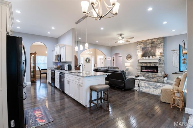 12200 Country Oaks Dr, Rolla, MO 65401 - kitchen featuring appliances with stainless steel finishes, arched walkways, open floor plan, a chandelier, and a stone fireplace