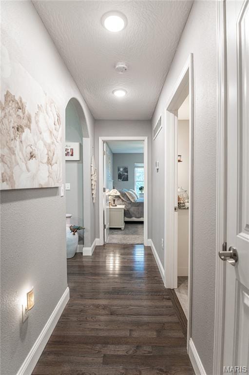 12200 Country Oaks Dr, Rolla, MO 65401 - hall with a textured ceiling, dark wood-type flooring, and arched walkways