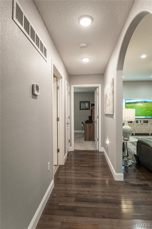 12200 Country Oaks Dr, Rolla, MO 65401 - hall featuring wood finished floors, arched walkways, and a textured ceiling