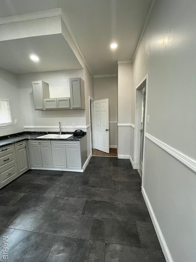 5350 Claxton Ave, Saint Louis, MO 63120 - kitchen featuring ornamental molding, dark countertops, gray cabinets, and dark stone finish flooring