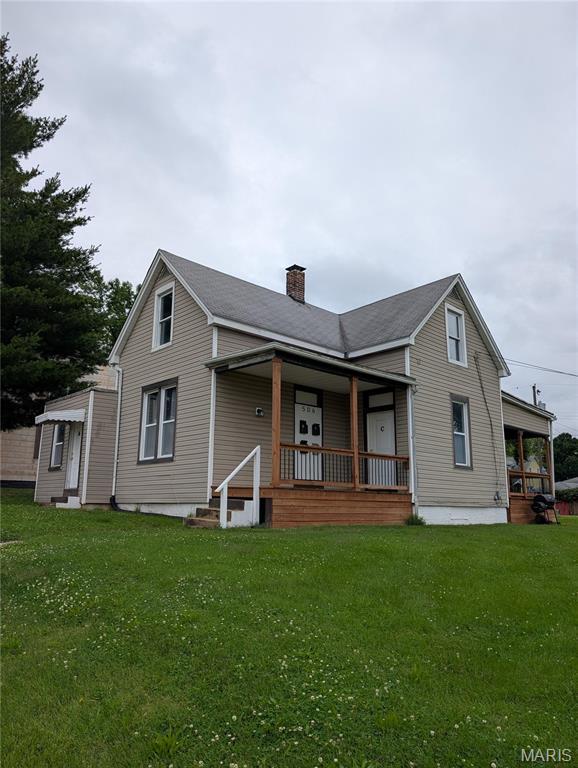 506 N 17th St, Belleville, IL 62226 - view of front of house with a chimney, a porch, and a front lawn