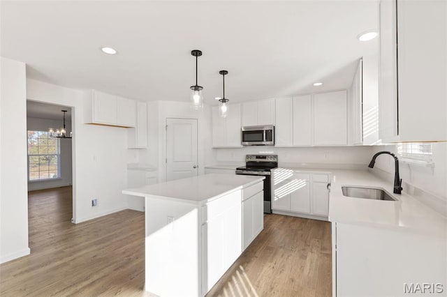 807 Colony Ridge Ct, Foristell, MO 63348 - kitchen with stainless steel appliances, a chandelier, a center island, light wood finished floors, and light countertops