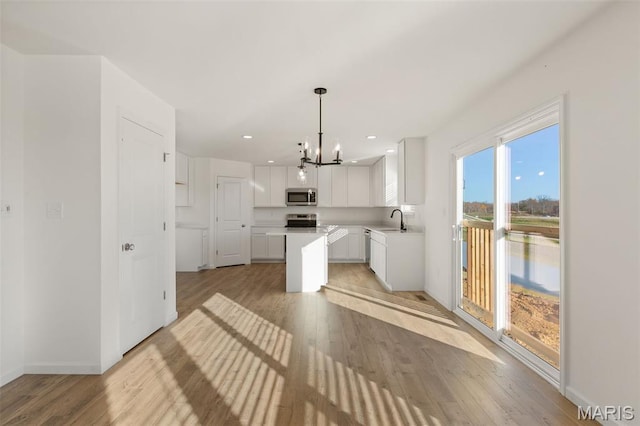 807 Colony Ridge Ct, Foristell, MO 63348 - kitchen featuring stainless steel microwave, range, a chandelier, light wood-type flooring, and recessed lighting