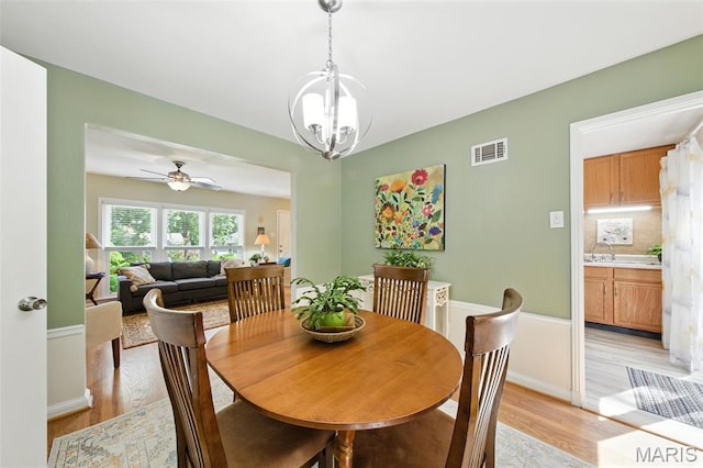 7142 Circleview Dr, Gravois Township, MO 63123 - dining space featuring light wood-type flooring, a chandelier, and ceiling fan