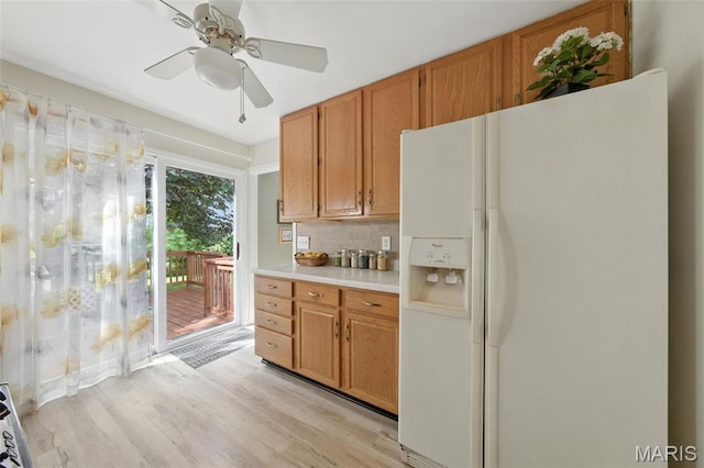 7142 Circleview Dr, Gravois Township, MO 63123 - kitchen with white fridge with ice dispenser, backsplash, light countertops, light wood-type flooring, and a ceiling fan