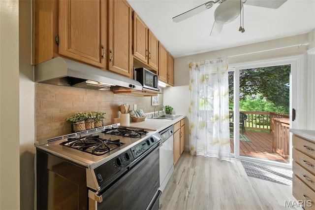 7142 Circleview Dr, Gravois Township, MO 63123 - kitchen with appliances with stainless steel finishes, under cabinet range hood, light wood-style floors, a ceiling fan, and backsplash