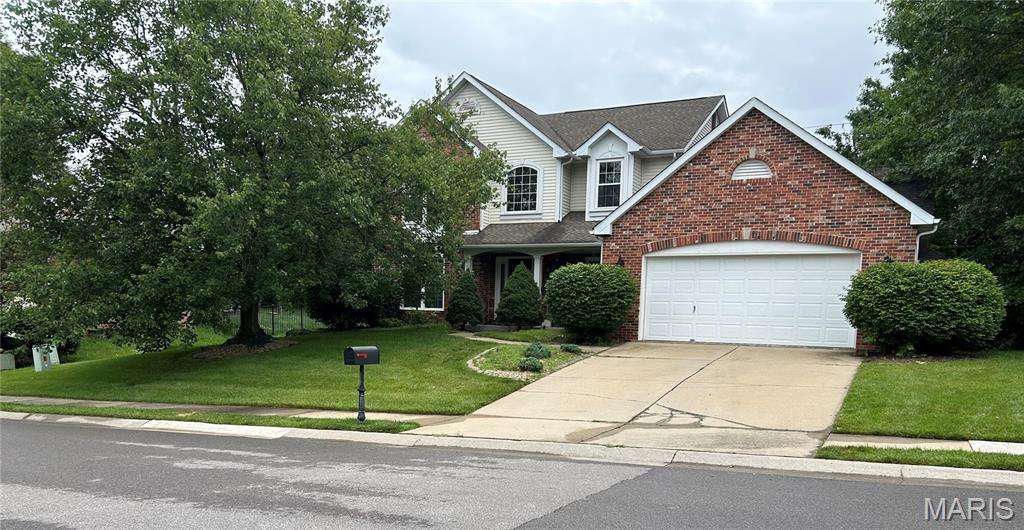 1302 Bossler Ln, Ofallon, IL 62269 - traditional home featuring brick siding, concrete driveway, and a front lawn