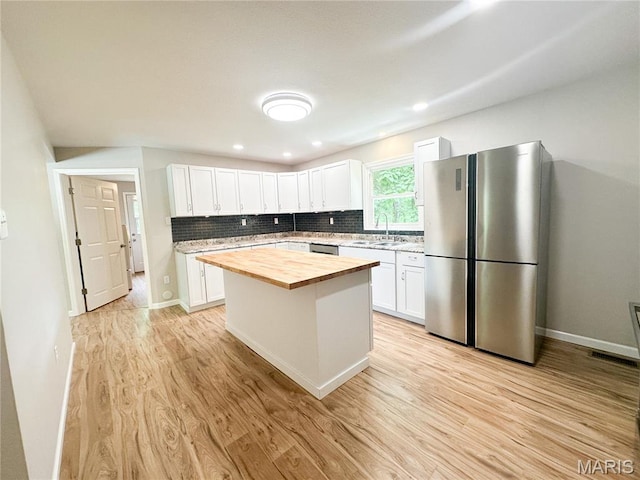 66 County Road 6680, Salem, MO 65560 - kitchen with stainless steel appliances, butcher block counters, white cabinets, light wood-style floors, and tasteful backsplash