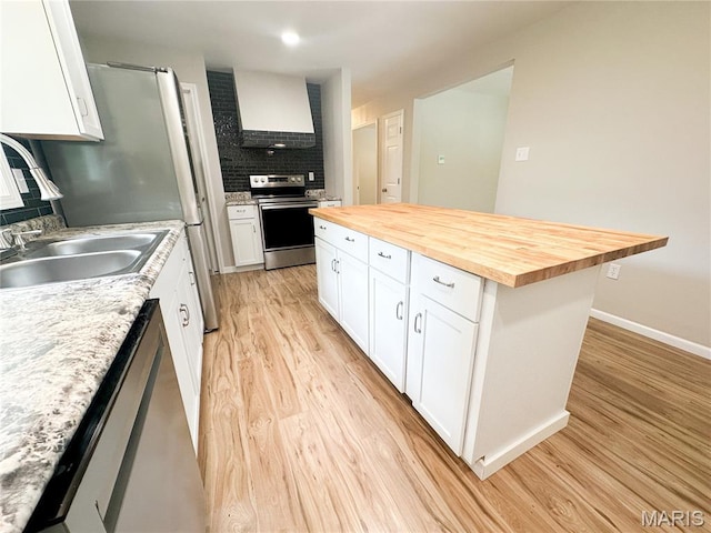 66 County Road 6680, Salem, MO 65560 - kitchen with stainless steel appliances, butcher block countertops, backsplash, light wood-type flooring, and white cabinets