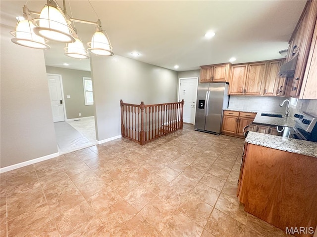 6484 County Road 3180, Salem, MO 65560 - kitchen with stainless steel fridge with ice dispenser, brown cabinetry, under cabinet range hood, light stone counters, and hanging light fixtures