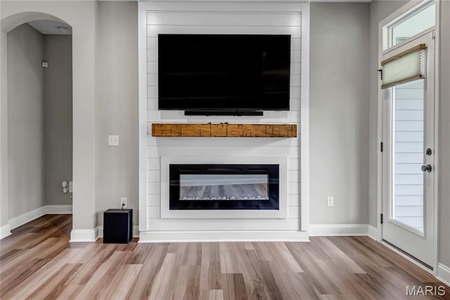 211 Cambium Ct, Wentzville, MO 63385 - unfurnished living room with wood finished floors, a fireplace, and arched walkways