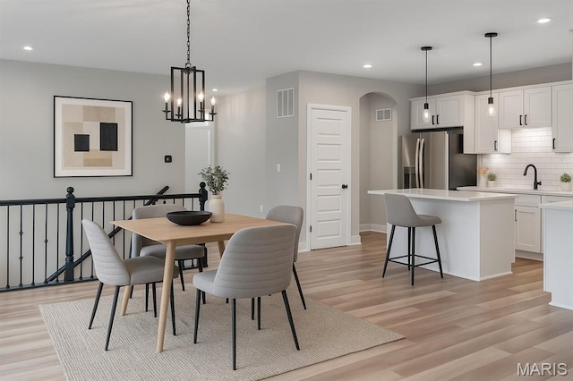 211 Cambium Ct, Wentzville, MO 63385 - dining area with recessed lighting, light wood-type flooring, arched walkways, and a chandelier