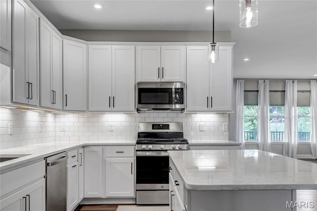211 Cambium Ct, Wentzville, MO 63385 - kitchen featuring stainless steel appliances, recessed lighting, a center island, white cabinets, and backsplash