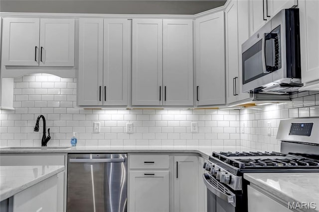 211 Cambium Ct, Wentzville, MO 63385 - kitchen with appliances with stainless steel finishes, backsplash, white cabinets, and light stone countertops