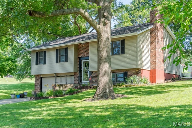 1003 Marilyn Ct, Washington, MO 63090 - split foyer home featuring a chimney, brick siding, an attached garage, a front yard, and asphalt driveway