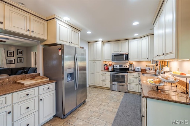 1003 Marilyn Ct, Washington, MO 63090 - kitchen featuring appliances with stainless steel finishes, dark stone countertops, stone finish flooring, recessed lighting, and open floor plan