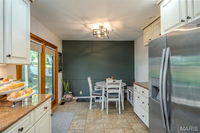1003 Marilyn Ct, Washington, MO 63090 - kitchen featuring stainless steel fridge, stone finish floors, light stone countertops, and a wainscoted wall