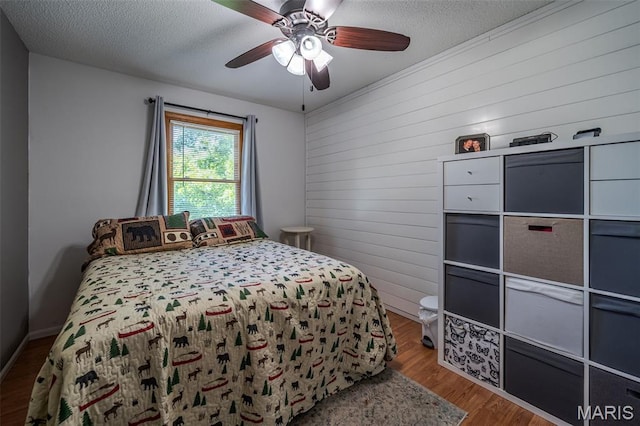 1003 Marilyn Ct, Washington, MO 63090 - bedroom with wood finished floors, a textured ceiling, a ceiling fan, and wooden walls
