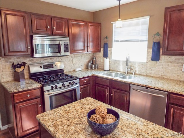 4 Green Circle Ct, Saint Peters, MO 63376 - kitchen featuring appliances with stainless steel finishes, light stone countertops, reddish brown cabinets, and tasteful backsplash