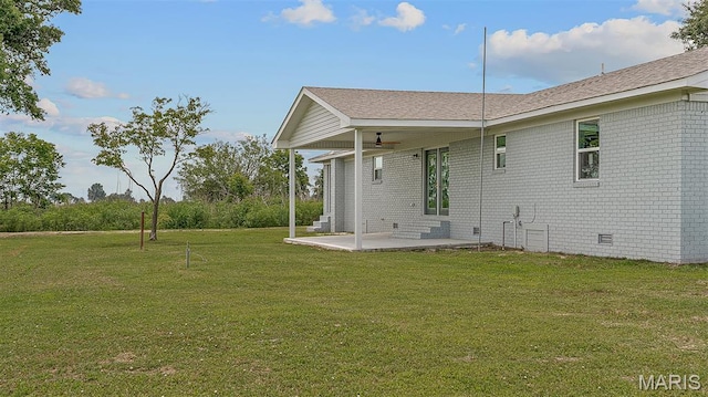 3120 State Highway F, Cardwell, MO 63829 - back of property featuring a patio, a yard, brick siding, roof with shingles, and crawl space