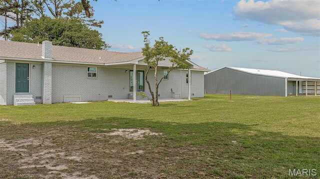 3120 State Highway F, Cardwell, MO 63829 - back of property featuring a lawn, an outbuilding, brick siding, a patio, and a chimney