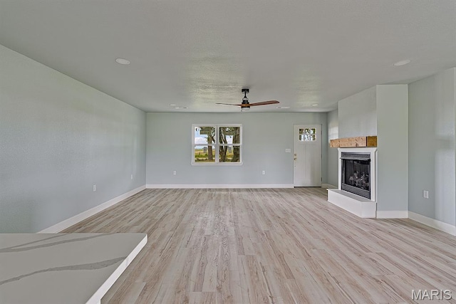 3120 State Highway F, Cardwell, MO 63829 - unfurnished living room featuring light wood finished floors, a tile fireplace, and ceiling fan