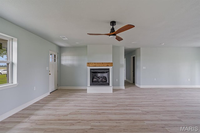 3120 State Highway F, Cardwell, MO 63829 - unfurnished living room with light wood-type flooring, a fireplace with raised hearth, and ceiling fan