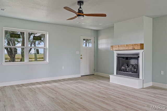 3120 State Highway F, Cardwell, MO 63829 - unfurnished living room with light wood-style floors, a ceiling fan, and a fireplace with raised hearth