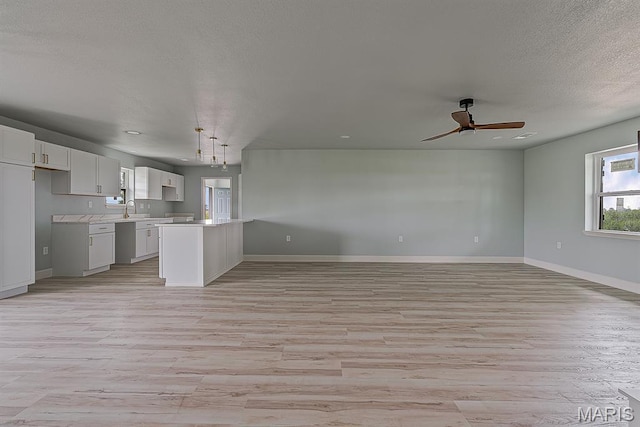 3120 State Highway F, Cardwell, MO 63829 - kitchen with open floor plan, light wood-style floors, ceiling fan, light countertops, and a textured ceiling