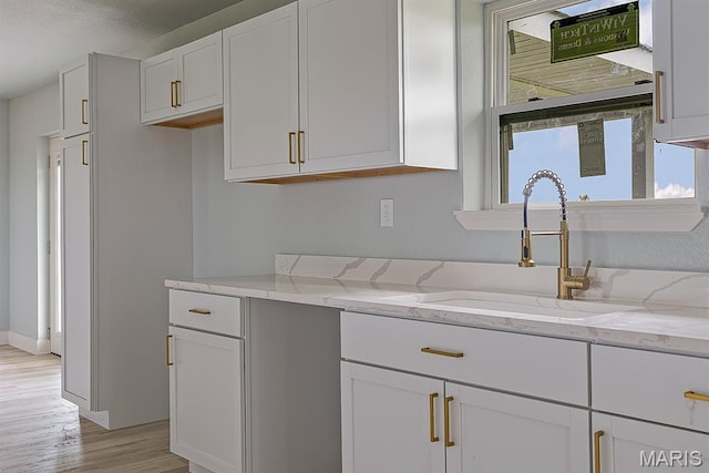 3120 State Highway F, Cardwell, MO 63829 - kitchen with light stone counters, light wood-style flooring, and white cabinetry