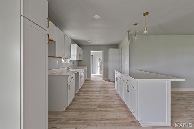 3120 State Highway F, Cardwell, MO 63829 - kitchen featuring light wood-type flooring, light stone counters, and white cabinets