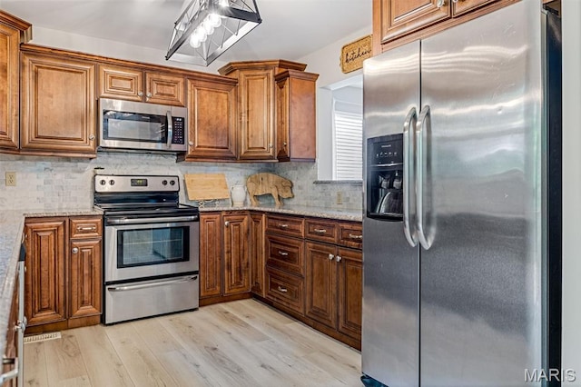 404 Arbor Spring Dr, Ballwin, MO 63021 - kitchen with appliances with stainless steel finishes, brown cabinetry, and light stone counters