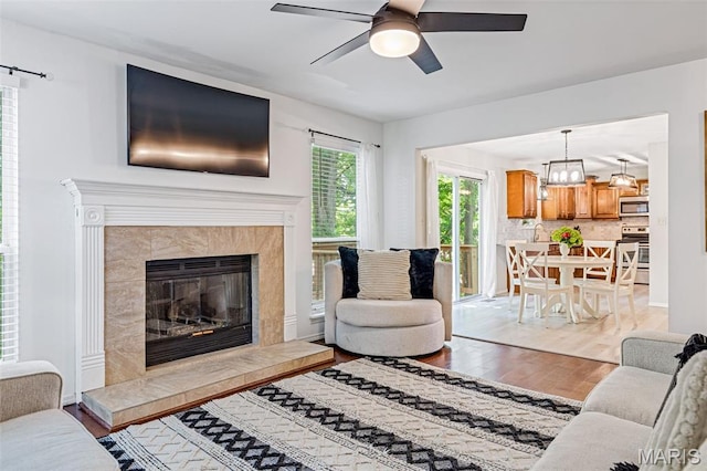 404 Arbor Spring Dr, Ballwin, MO 63021 - living room with light wood finished floors, ceiling fan, and a tile fireplace