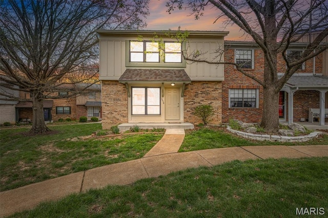 2318 Hidden Meadow Ln, Ballwin, MO 63021 - view of front facade featuring brick siding, a yard, and board and batten siding
