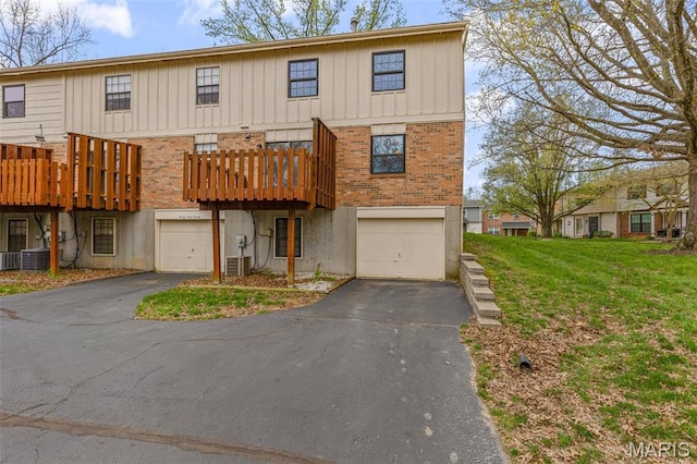2318 Hidden Meadow Ln, Ballwin, MO 63021 - townhome / multi-family property featuring driveway, board and batten siding, brick siding, an attached garage, and a front lawn