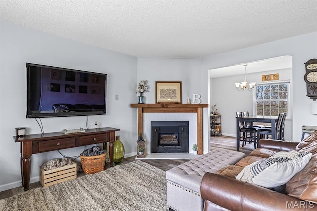2318 Hidden Meadow Ln, Ballwin, MO 63021 - living area featuring a chandelier, wood finished floors, a textured ceiling, and a fireplace