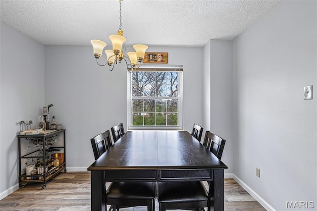 2318 Hidden Meadow Ln, Ballwin, MO 63021 - dining space with a chandelier, a textured ceiling, and wood finished floors