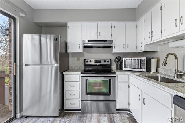 2318 Hidden Meadow Ln, Ballwin, MO 63021 - kitchen with appliances with stainless steel finishes, under cabinet range hood, healthy amount of natural light, and white cabinets