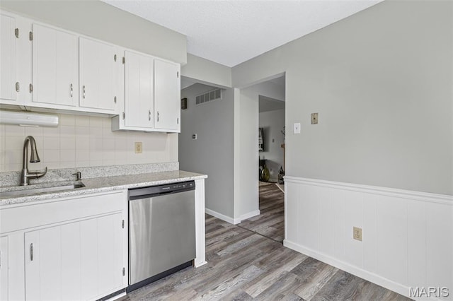 2318 Hidden Meadow Ln, Ballwin, MO 63021 - kitchen featuring dishwasher, light wood-style floors, tasteful backsplash, a wainscoted wall, and white cabinets