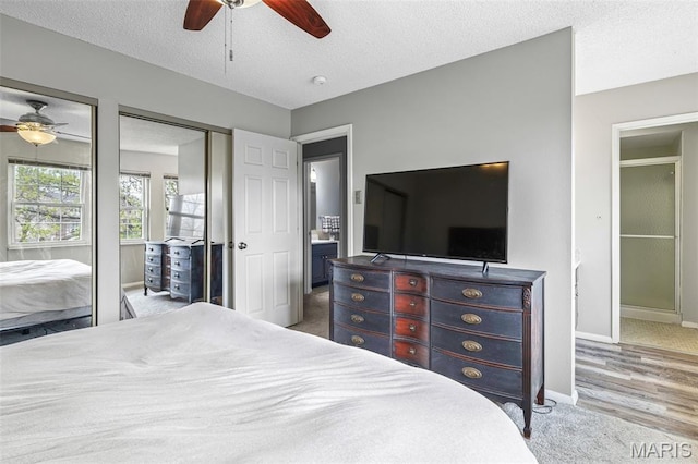 2318 Hidden Meadow Ln, Ballwin, MO 63021 - carpeted bedroom featuring multiple closets, ceiling fan, and a textured ceiling