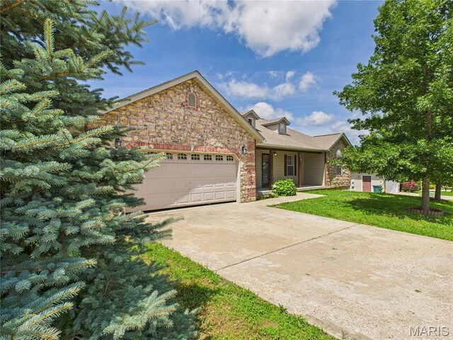 16107 Hummingbird Ln, Saint Robert, MO 65584 - view of front of house featuring a garage, stone siding, concrete driveway, and a front yard