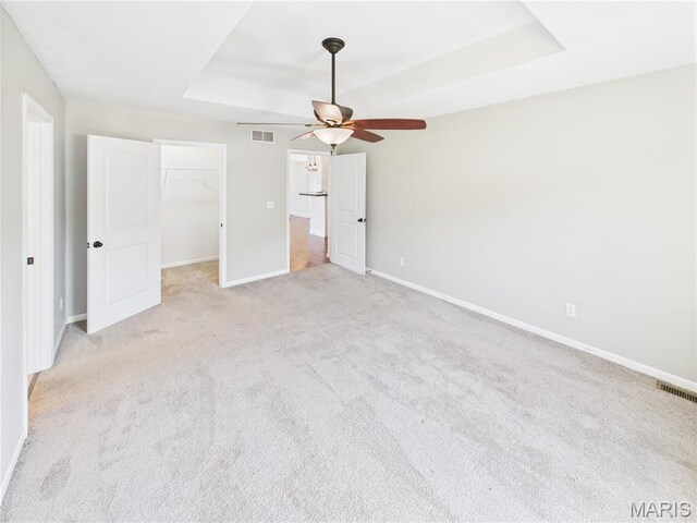 16107 Hummingbird Ln, Saint Robert, MO 65584 - unfurnished bedroom featuring a raised ceiling, carpet, a walk in closet, a closet, and a ceiling fan