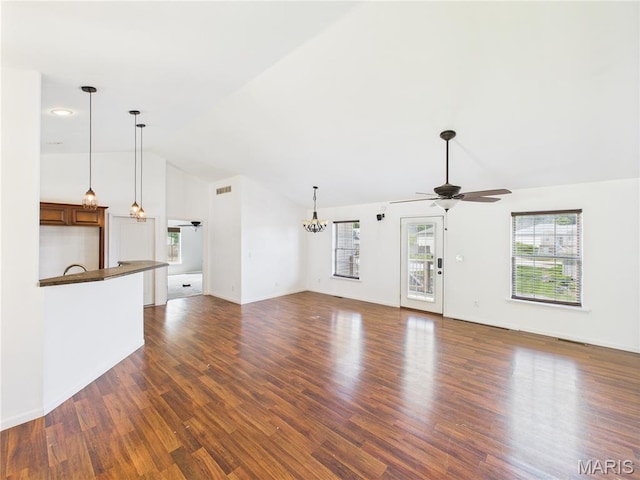16107 Hummingbird Ln, Saint Robert, MO 65584 - unfurnished living room featuring a ceiling fan, plenty of natural light, a chandelier, lofted ceiling, and dark wood-type flooring